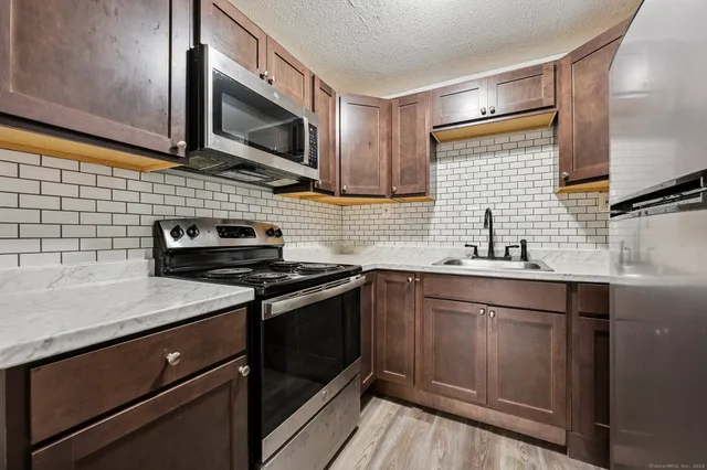 a kitchen with stainless steel appliances a sink dishwasher stove microwave and cabinets