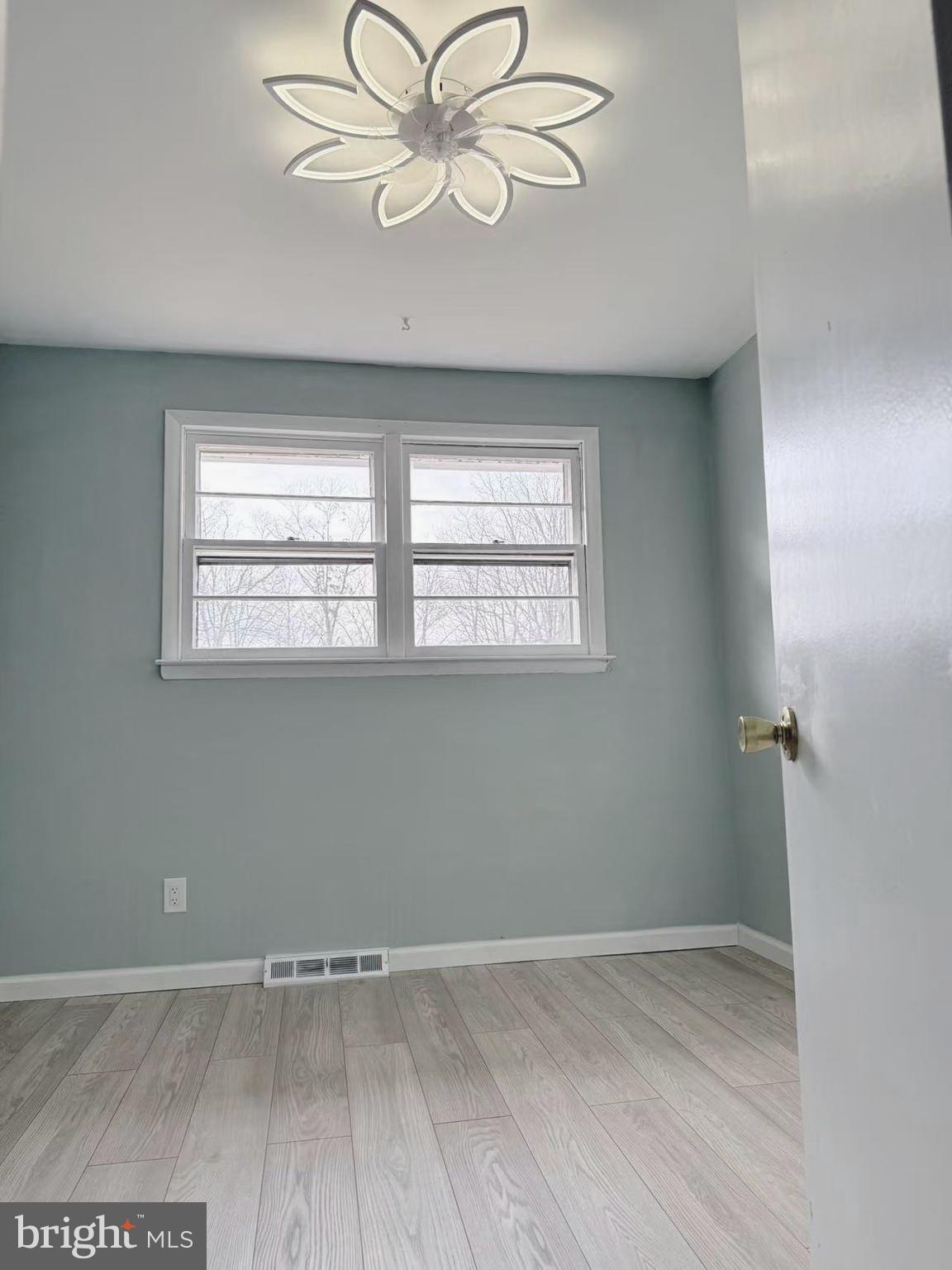 4529 Robin Road Newfield, NJ 08344 - Photo 21 of 39 an empty room with wooden floor chandelier fan and windows