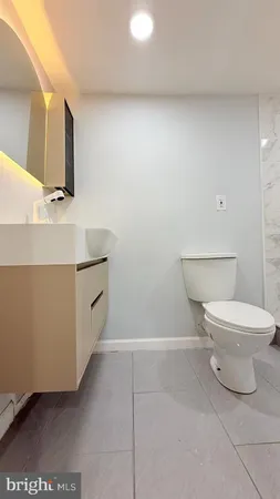 a bathroom with a toilet a sink and mirror