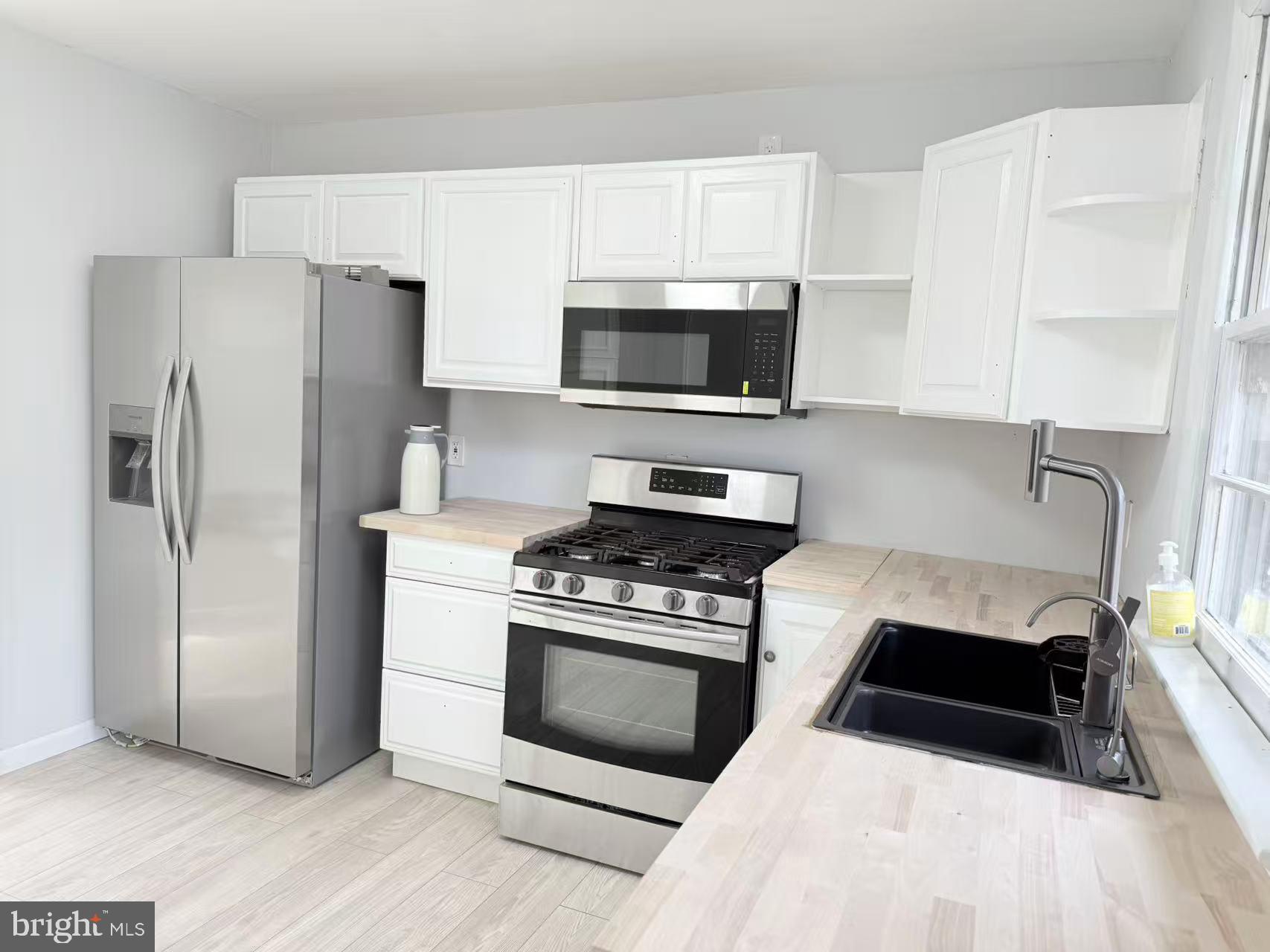 4529 Robin Road Newfield, NJ 08344 - Photo 10 of 39 a kitchen with white cabinets and stainless steel appliances