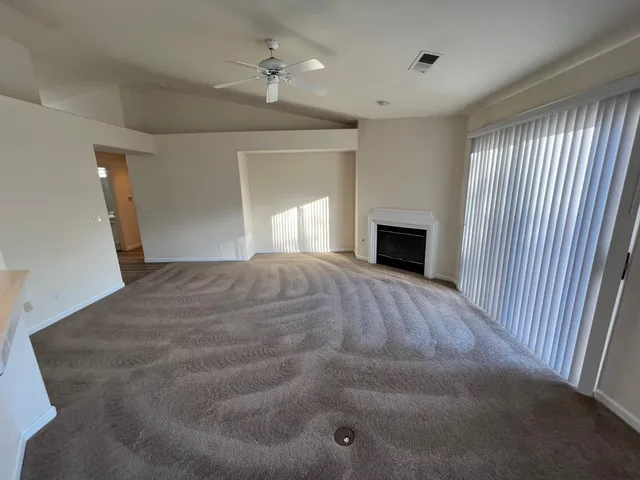 a view of empty room with fireplace and windows