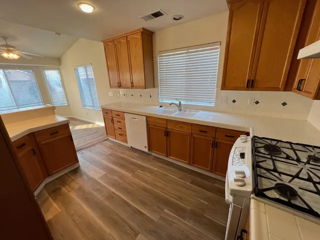 a kitchen with stainless steel appliances granite countertop a sink and wooden cabinets