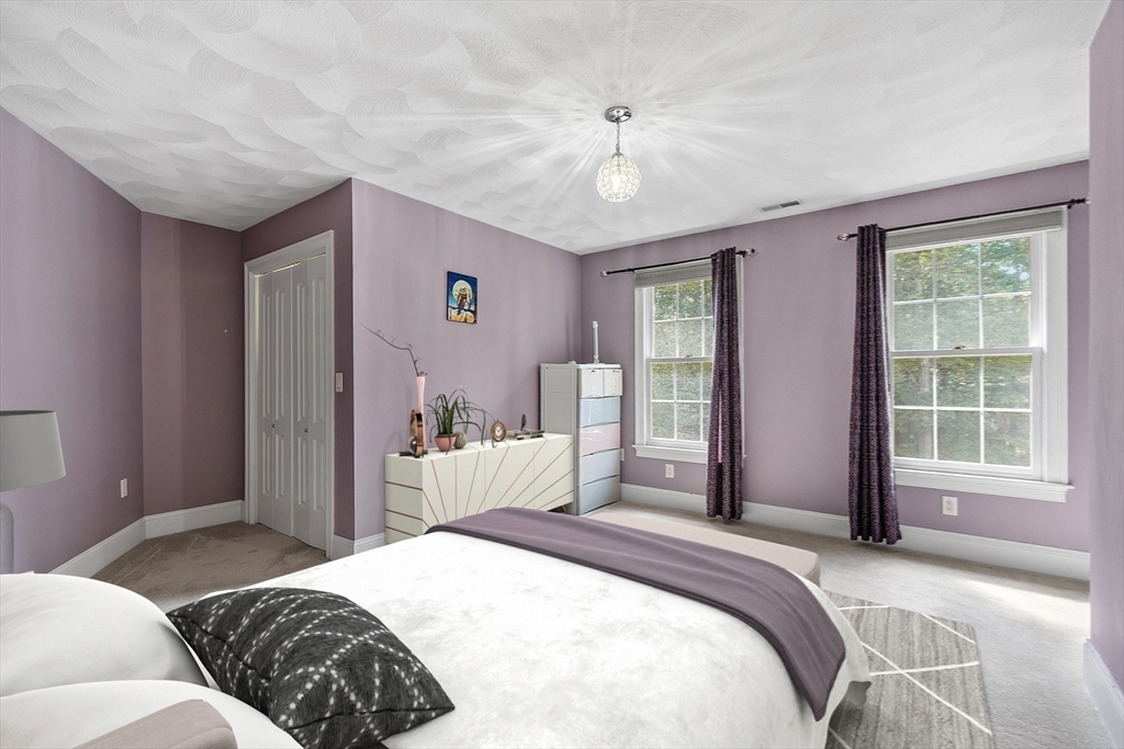 19 Barton Road Harvard, MA 01451 - Photo 14 of 20 a bedroom with a large bed and a chandelier