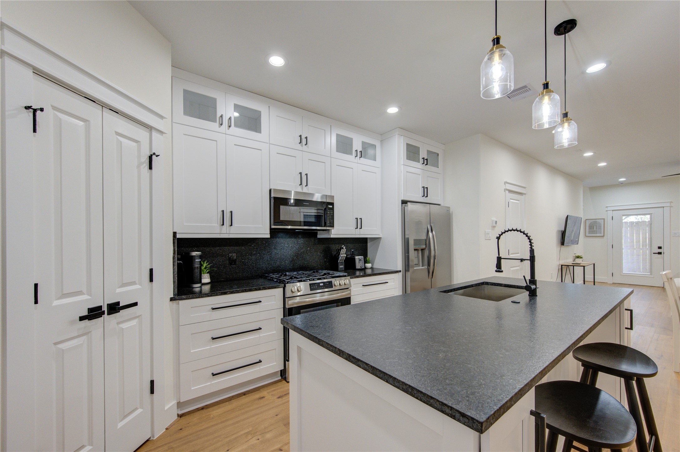 3406 Garapan Street, Unit A Houston, TX 77091 - Photo 11 of 44 a kitchen with stainless steel appliances a table chairs and a refrigerator