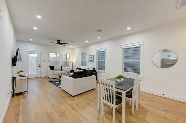 a living room with furniture a wooden floor and next to a window
