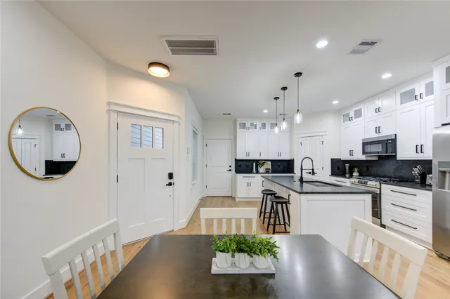 a large white kitchen with lots of counter space a sink a window and stainless steel appliances