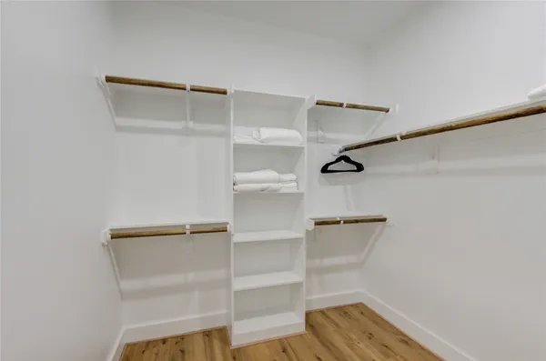 a view of walk in closet with empty racks