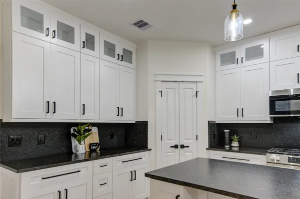 a kitchen with stainless steel appliances white cabinets and a sink