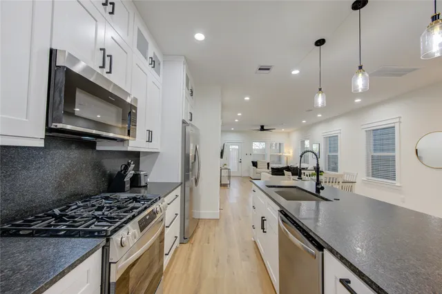 a kitchen with stainless steel appliances sink stove microwave and cabinets
