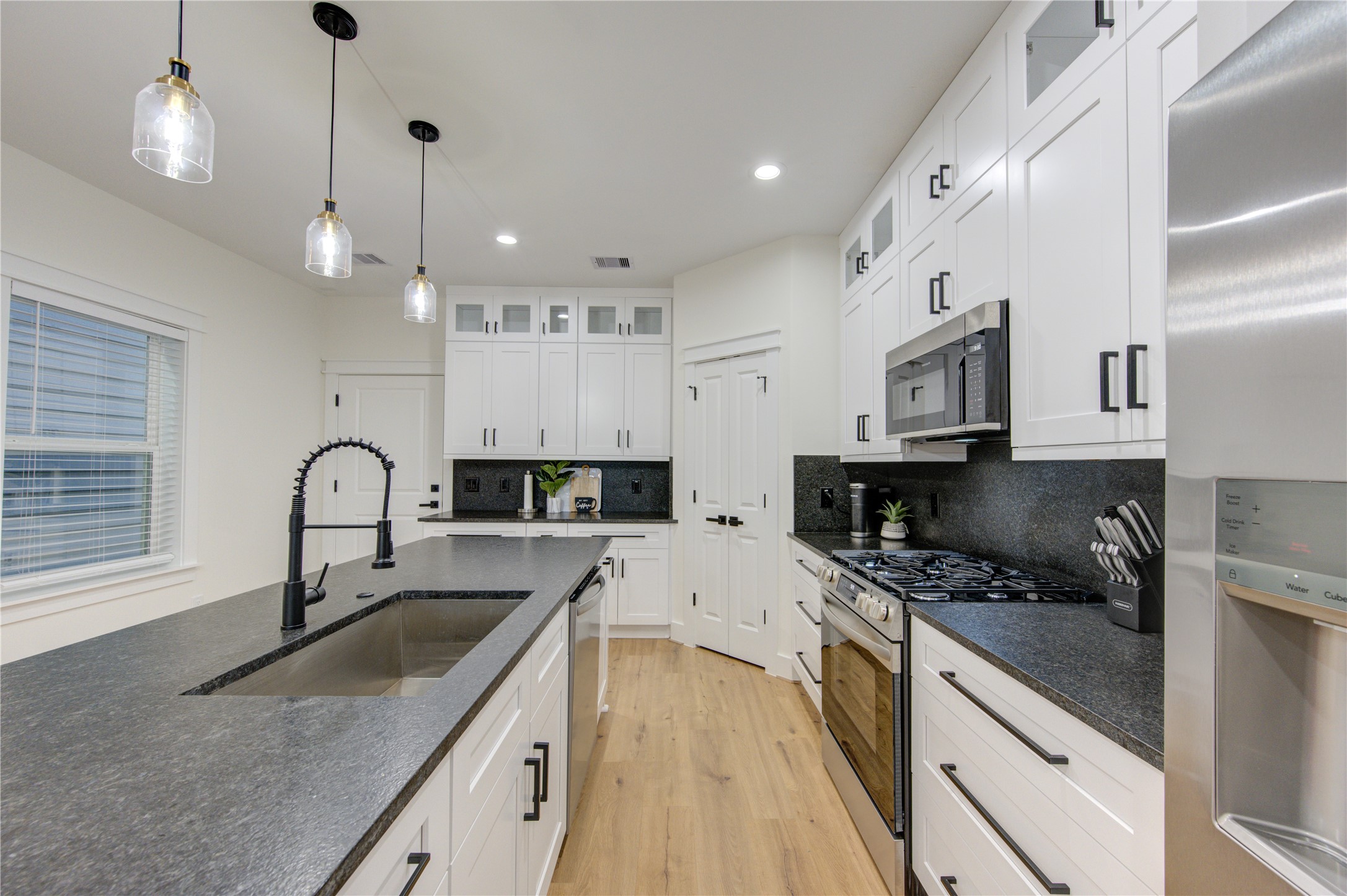 3406 Garapan Street, Unit A Houston, TX 77091 - Photo 10 of 44 a kitchen with granite countertop a sink a counter space appliances and cabinets