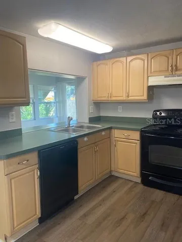 a kitchen with granite countertop white cabinets and black appliances