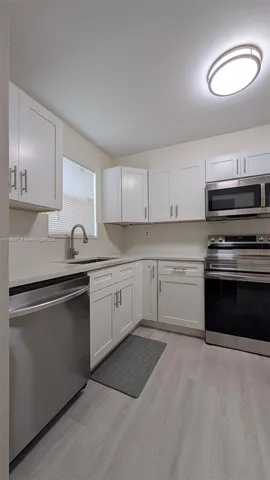 a large kitchen with stainless steel appliances granite countertop a stove and a sink