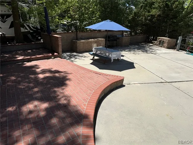 a view of backyard with table and chairs under an umbrella