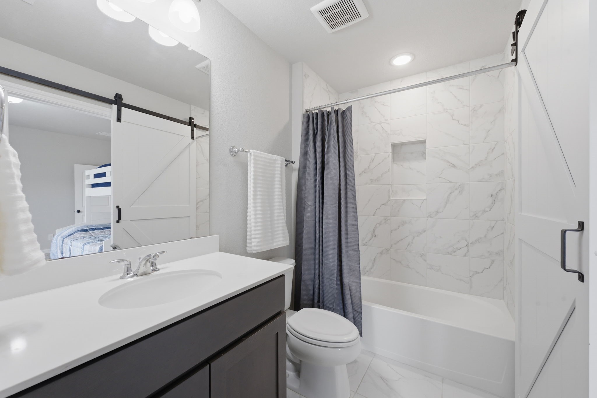 4242 Orchard Pass Drive Spring, TX 77386 - Photo 37 of 50 Full Ensuite Bath w/ Barn Door in Front Secondary Bedroom. Tile To Ceiling Tub/Shower with Quartz Vanity and Walk In Closet