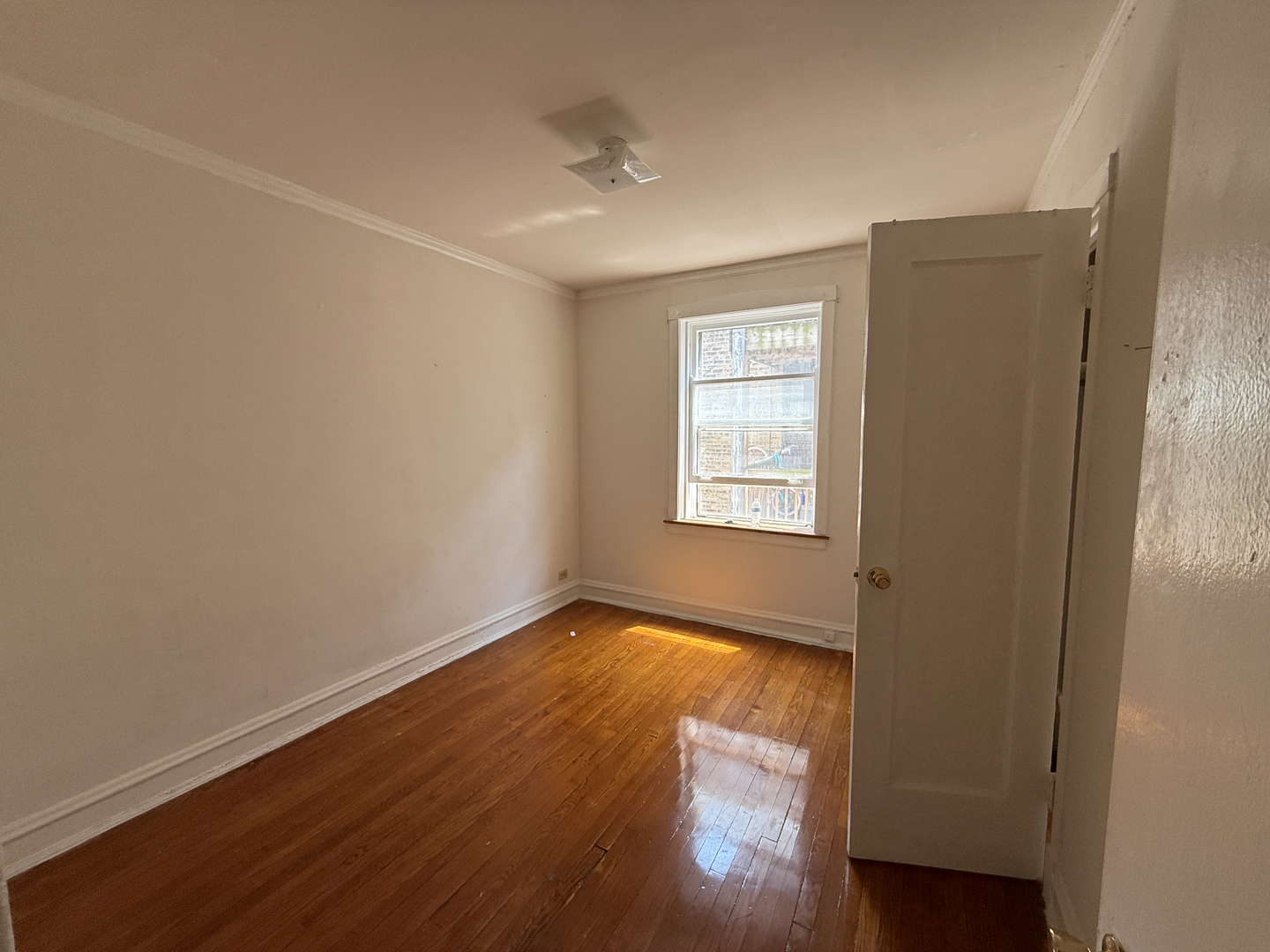 7415 North Damen Avenue, Unit 2E Chicago, IL 60645 - Photo 6 of 8 an empty room with wooden floor and windows