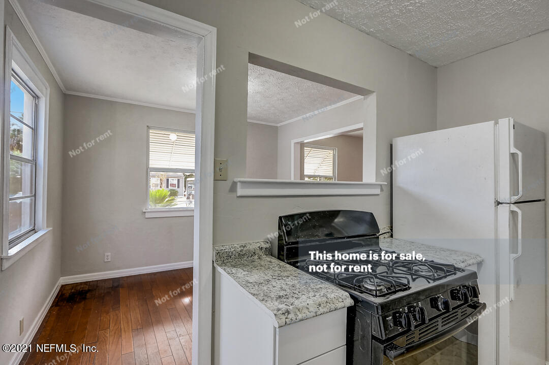 4617 Pinewood Road Jacksonville, FL 32210 - Photo 12 of 18 a kitchen with a stove a refrigerator and a window