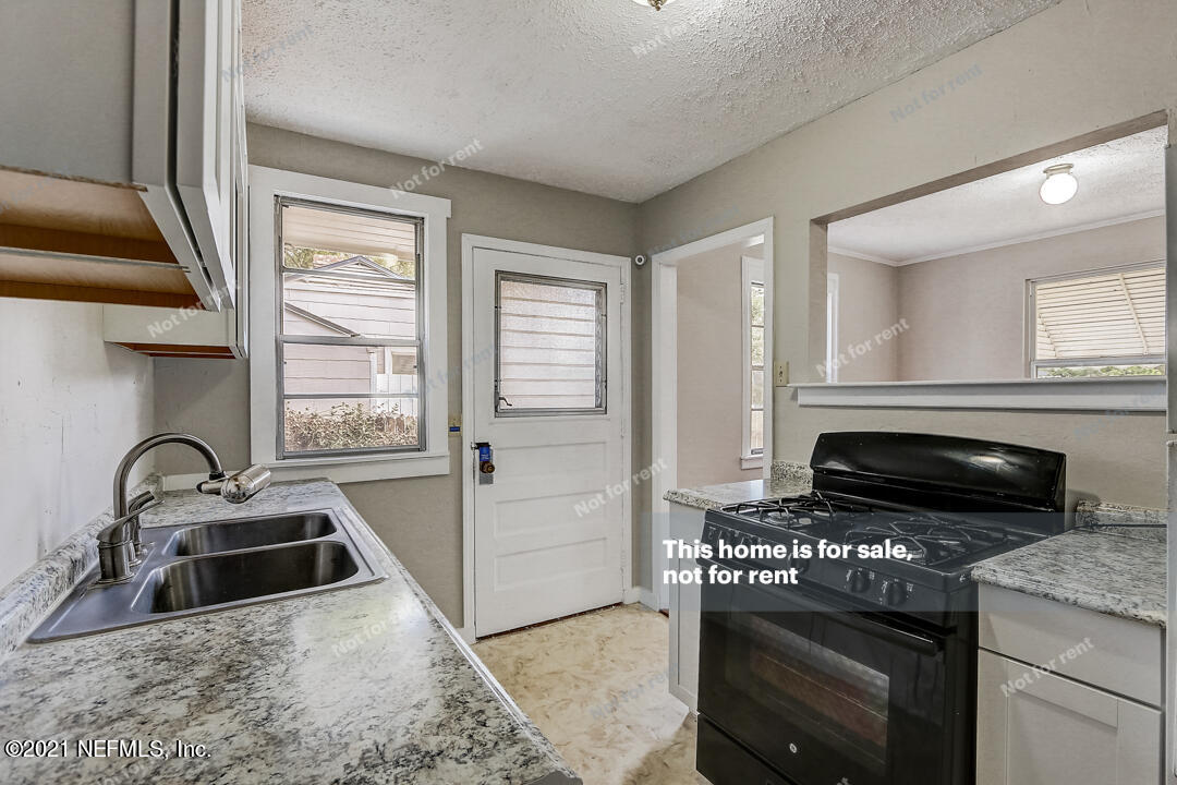 4617 Pinewood Road Jacksonville, FL 32210 - Photo 13 of 18 a kitchen with a stove a sink and a microwave