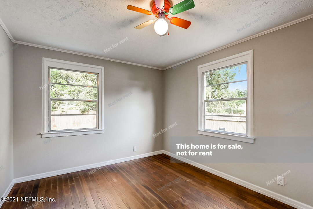 4617 Pinewood Road Jacksonville, FL 32210 - Photo 17 of 18 a view of an empty room with wooden floor and a window