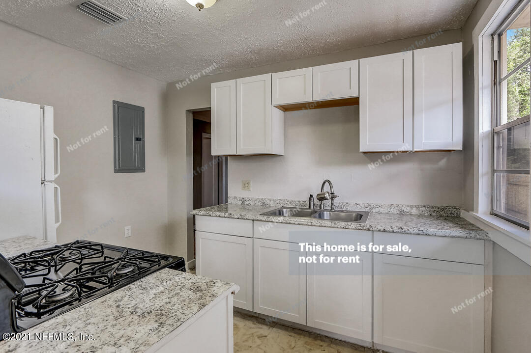 4617 Pinewood Road Jacksonville, FL 32210 - Photo 2 of 18 a kitchen with a stove a sink and a cabinets