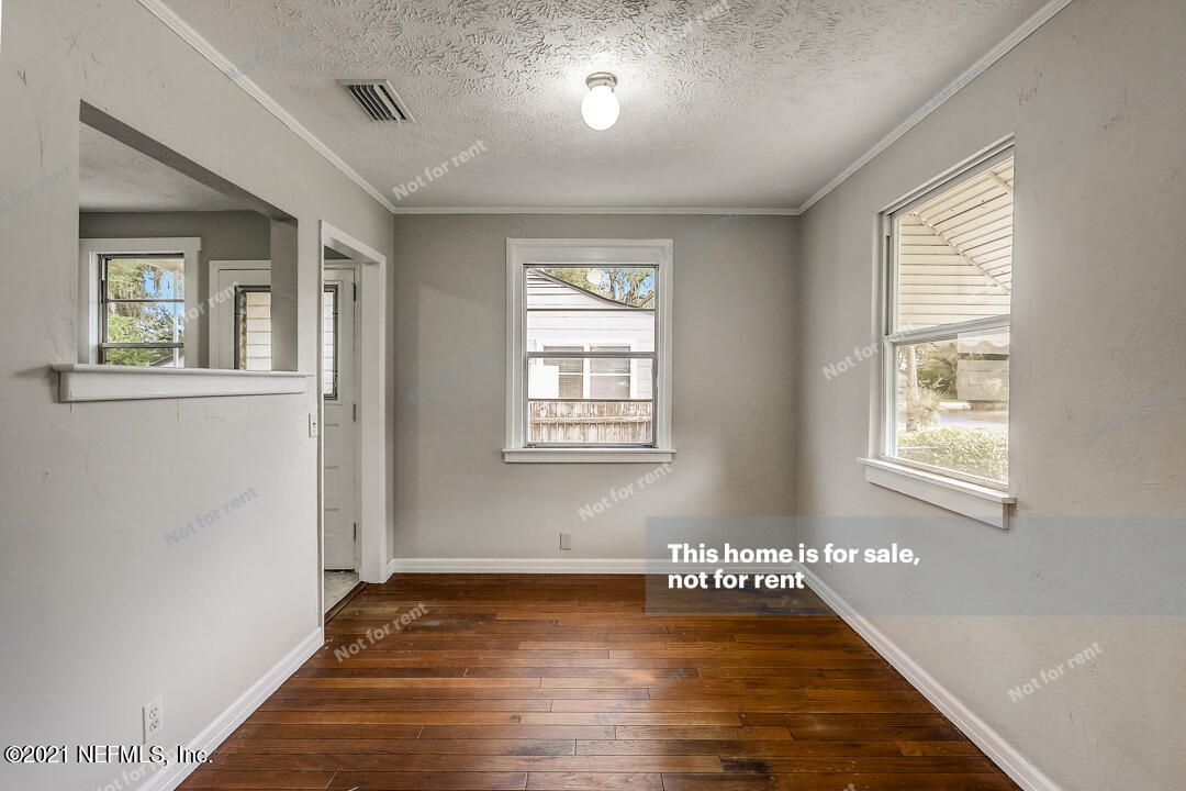 4617 Pinewood Road Jacksonville, FL 32210 - Photo 3 of 18 a view of an empty room with wooden floor and a window