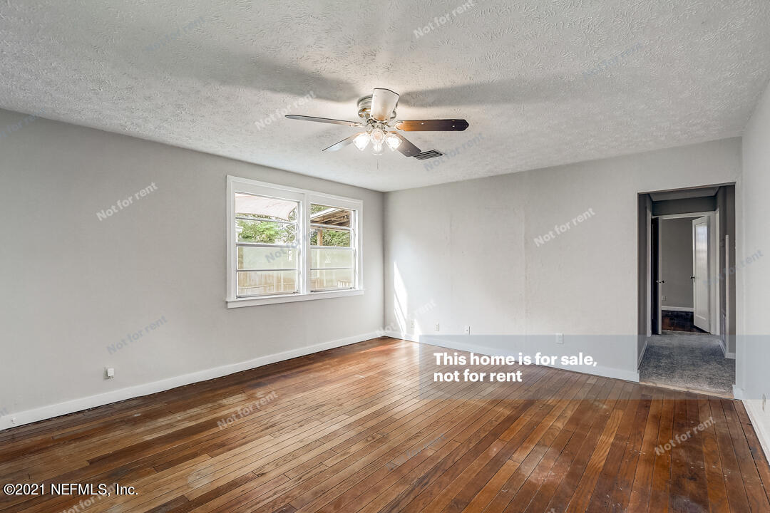 4617 Pinewood Road Jacksonville, FL 32210 - Photo 4 of 18 a view of an empty room with window and wooden floor