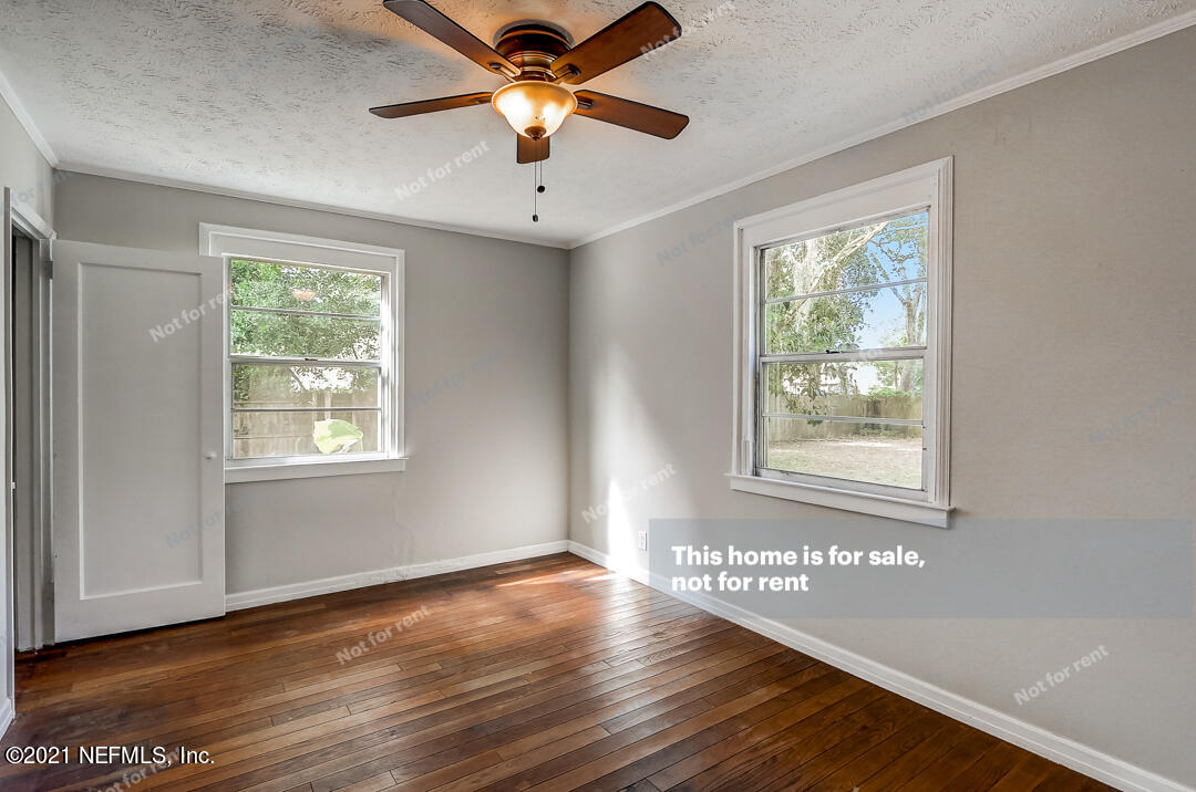 4617 Pinewood Road Jacksonville, FL 32210 - Photo 6 of 18 a view of an empty room with wooden floor and a window