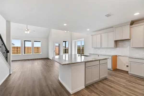 a kitchen with kitchen island granite countertop a sink a center island and cabinets