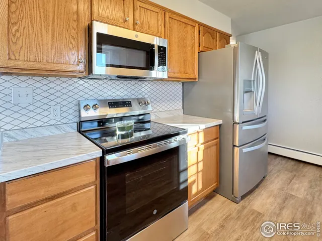 a kitchen with stainless steel appliances a stove microwave and refrigerator