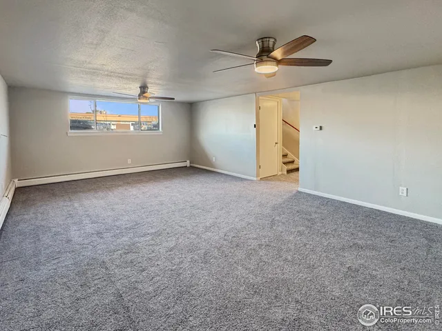 an empty room with a ceiling fan and a window
