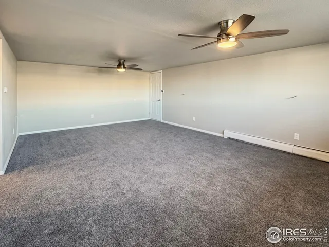 an empty room with a ceiling fan and a window