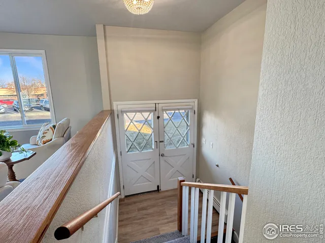 a view of a hallway with wooden floor and furniture