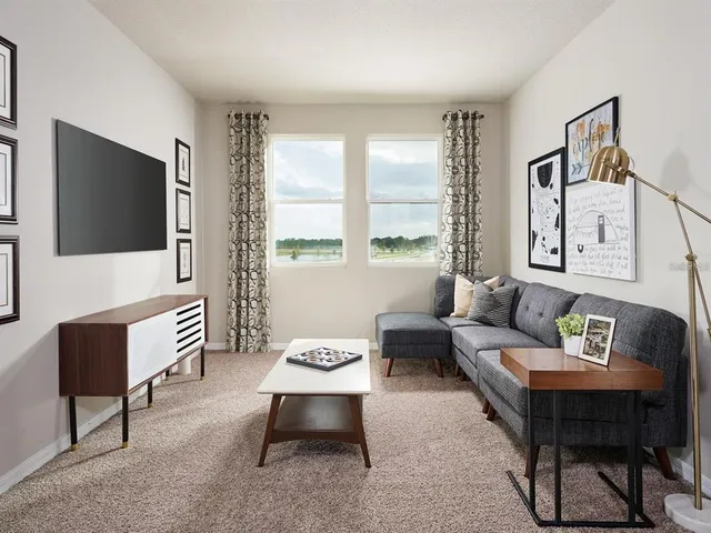 a living room with furniture a flat screen tv and a large window