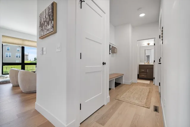 a view of a hallway with wooden floor and furniture