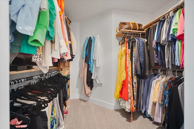 a view of walk in closet with clothes and shoes