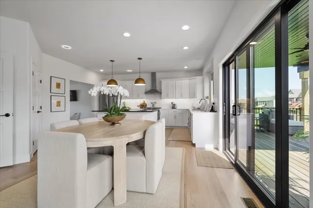 a dining hall with stainless steel appliances granite countertop furniture a large window and kitchen view