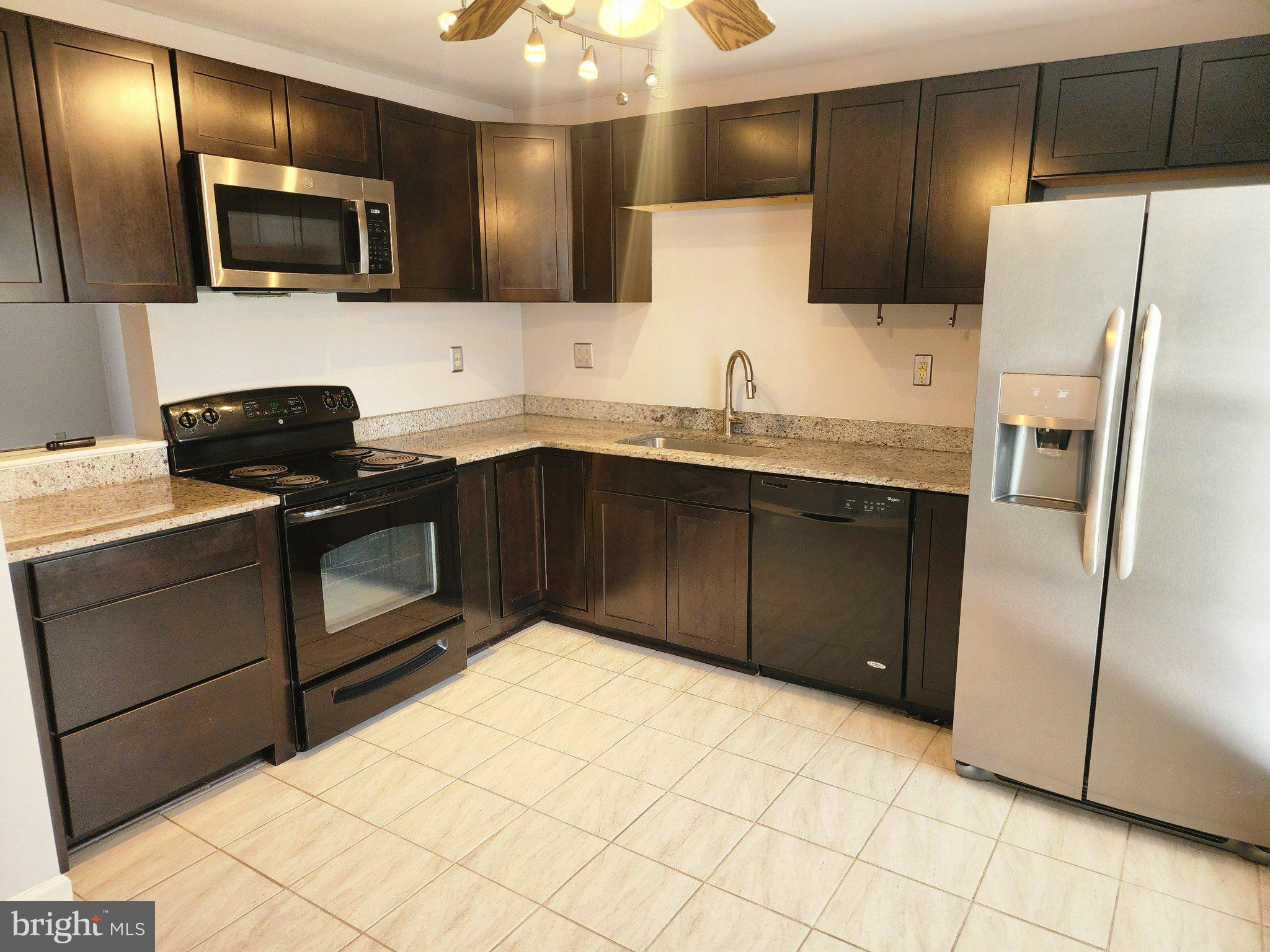 2384 Mitchellville Road Bowie, MD 20716 - Photo 6 of 44 a kitchen with stainless steel appliances wooden cabinets a sink and a stove