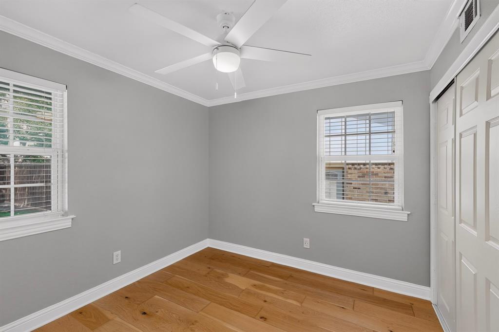 4404 Astor Road Mesquite, TX 75150 - Photo 24 of 38 Interior room featuring wood-finish flooring, two windows with blinds, a ceiling fan with integrated lighting, crown molding, and a sliding closet door