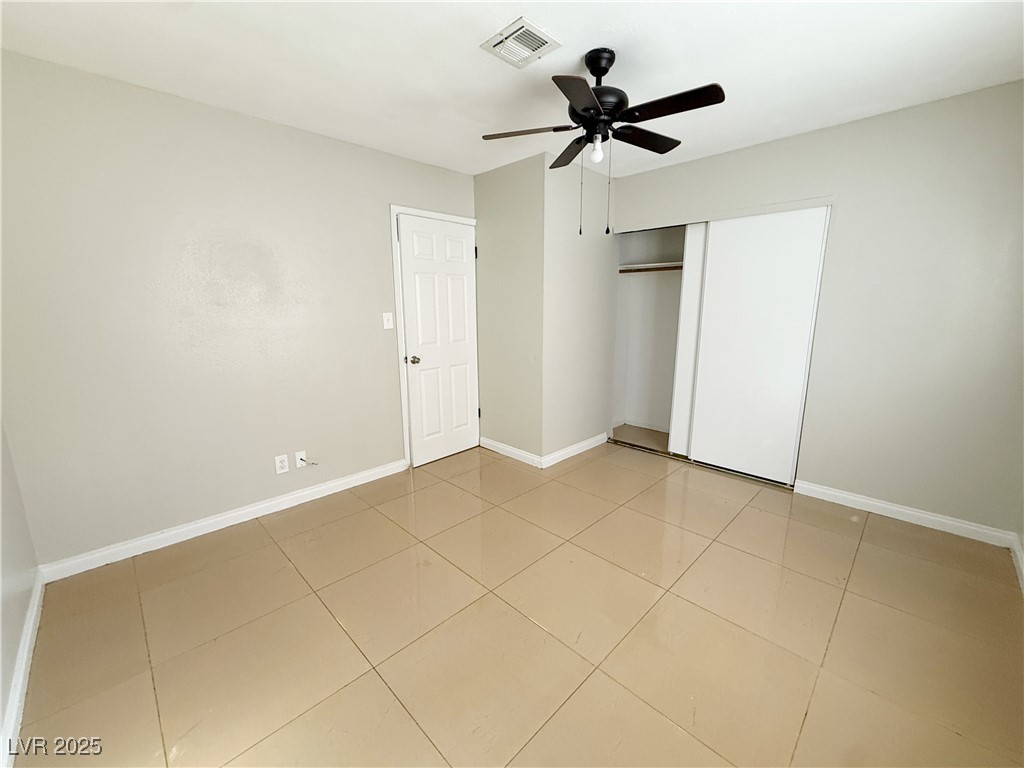 2353 Exeter Drive, Unit B Las Vegas, NV 89156 - Photo 13 of 16 Unfurnished bedroom with a closet, ceiling fan, and light tile patterned flooring
