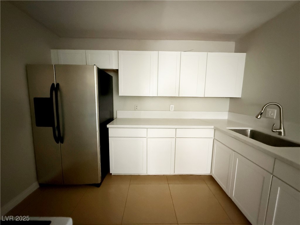2353 Exeter Drive, Unit B Las Vegas, NV 89156 - Photo 8 of 16 Kitchen featuring stainless steel fridge, white cabinets, and light tile patterned flooring
