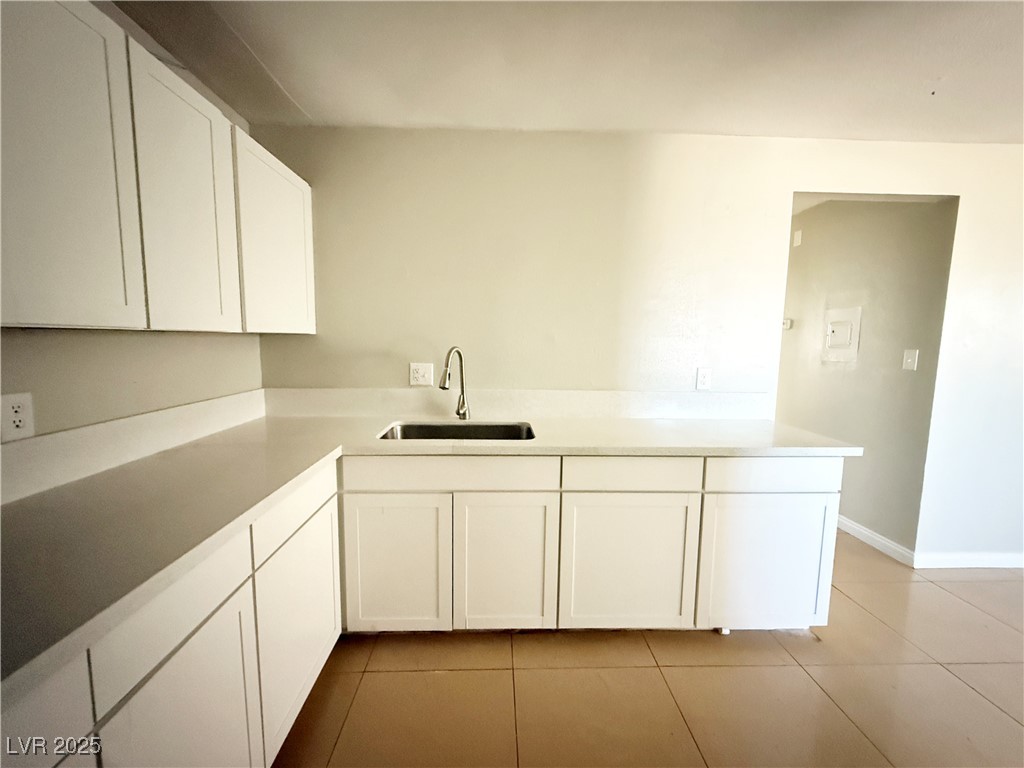 2353 Exeter Drive, Unit B Las Vegas, NV 89156 - Photo 9 of 16 Kitchen featuring white cabinetry and light tile patterned floors
