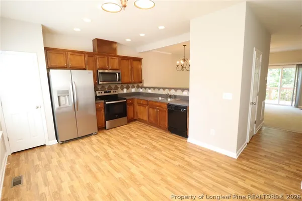 a kitchen with stainless steel appliances granite countertop a refrigerator and a stove top oven