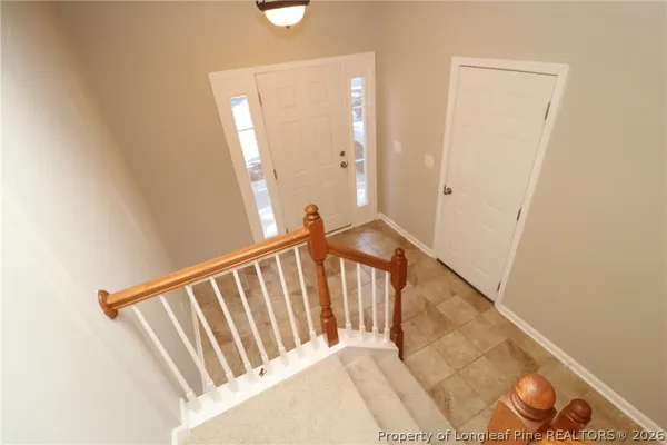 a view of a hallway with wooden floor and stairs