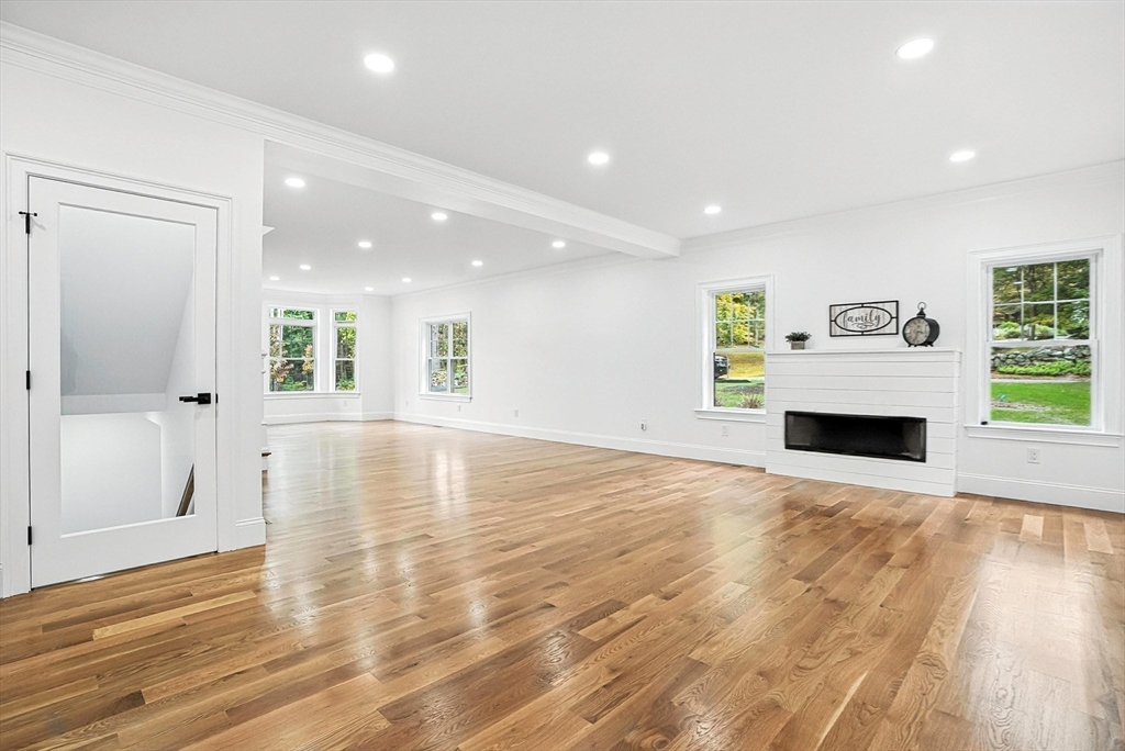 53 Cider Mill Lane Upton, MA 01568 - Photo 8 of 40 a view of a livingroom with a fireplace a ceiling fan and window
