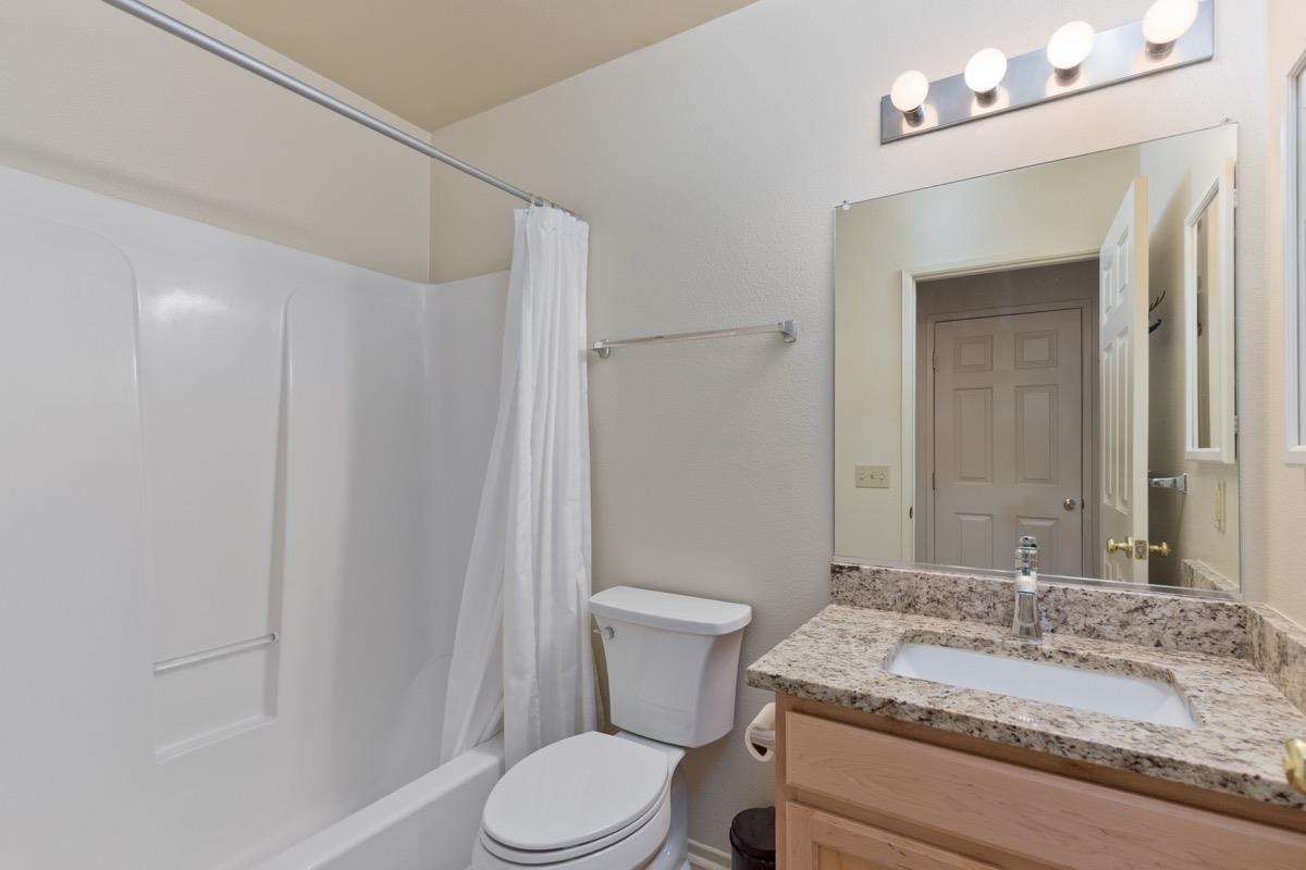 550 Mono Street, Unit C202 Mammoth Lakes, CA 93546 - Photo 11 of 36 a bathroom with a granite countertop sink vanity mirror and toilet