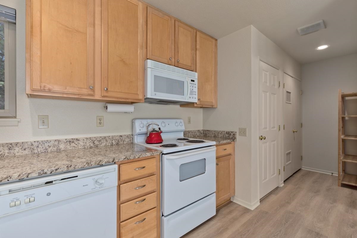 550 Mono Street, Unit C202 Mammoth Lakes, CA 93546 - Photo 7 of 36 a kitchen with granite countertop cabinets stainless steel appliances and a sink