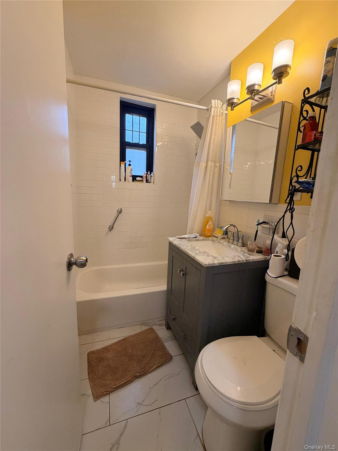 71-43 Park Drive East, Unit A Queens, NY 11367 - Photo 3 of 6 Full bathroom featuring vanity, shower / bathtub combination with curtain, and light marble finish flooring