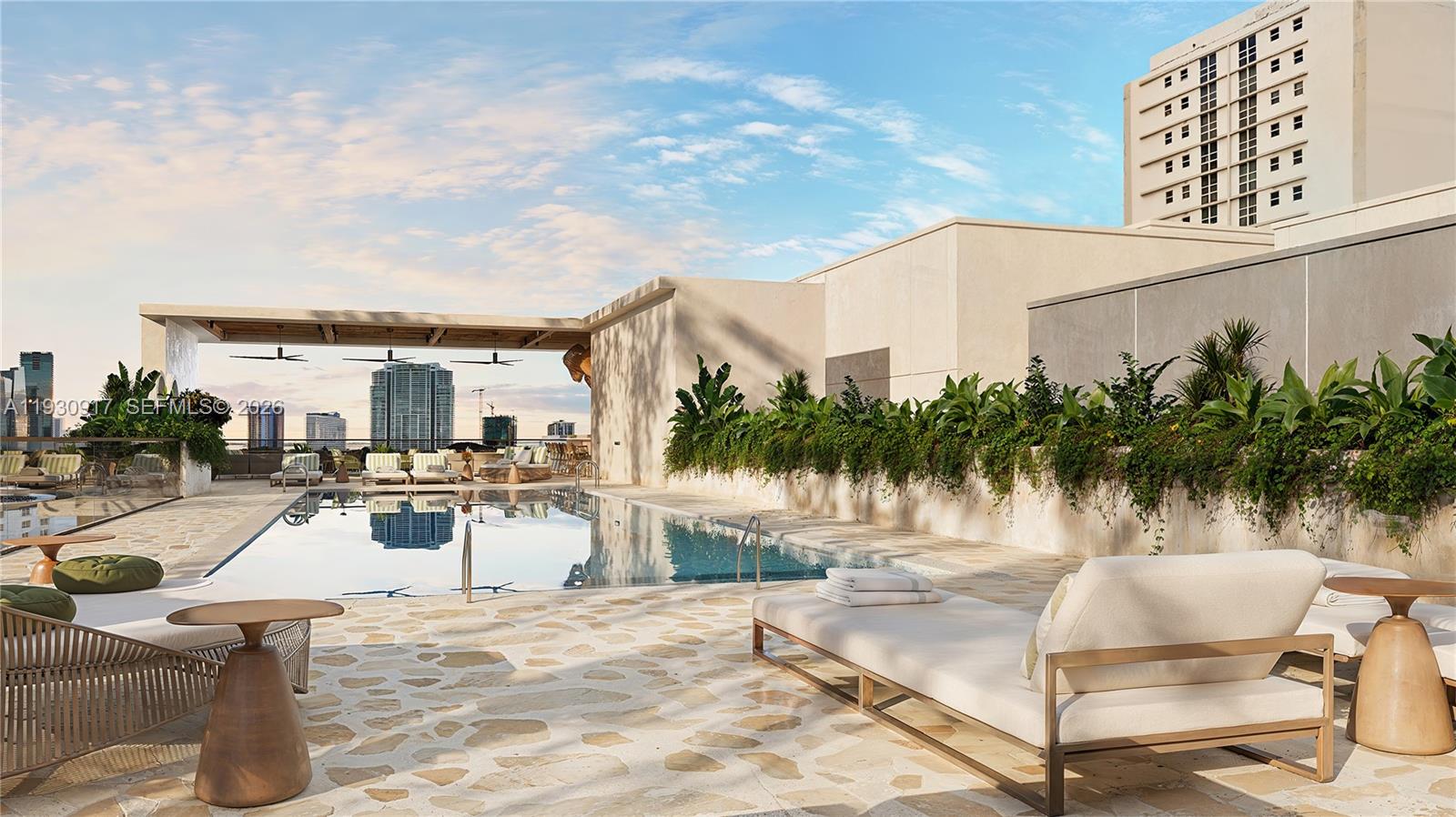 1741 Southwest 2nd Avenue, Unit 702 Miami, FL 33129 - Photo 12 of 17 a view of a swimming pool with a lounge chair and palm trees