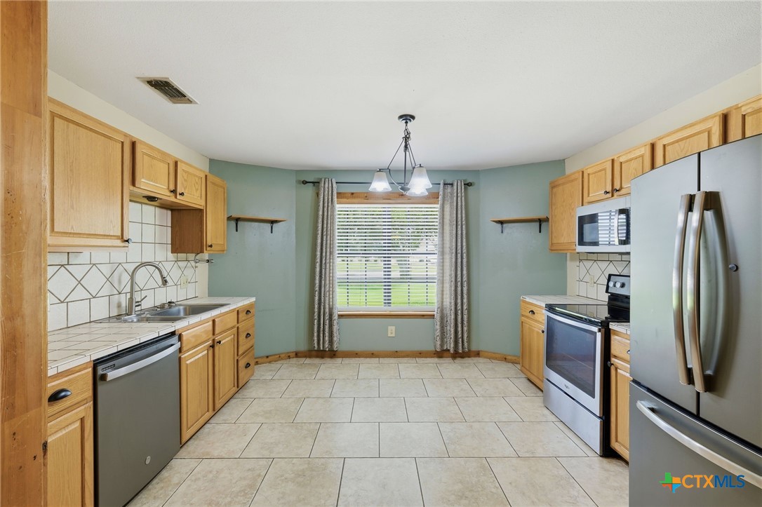 903 Summit Street Round Rock, TX 78664 - Photo 6 of 38 Large Kitchen area with a breakfast area in the bay window. Stainless appliances and room for a center island as well. Open to the expansive dinning area.