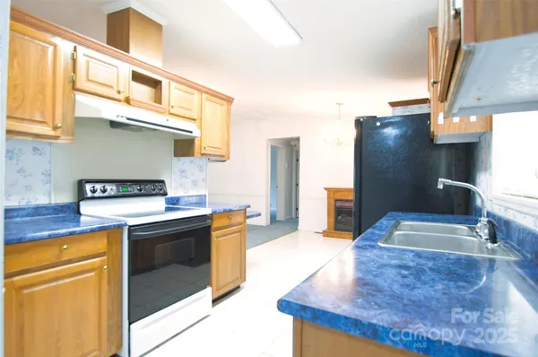 an empty room with chandelier fan and windows