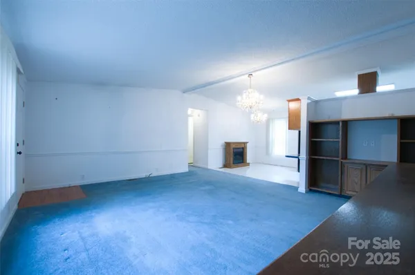 an empty room with wooden floor and fireplace